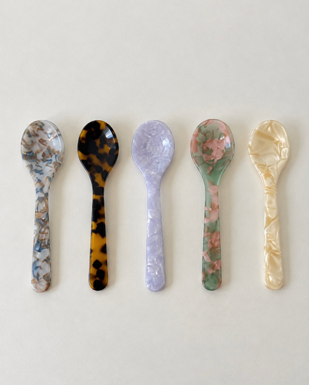 Five handmade acrylic dessert spoons in assorted marble patterns
